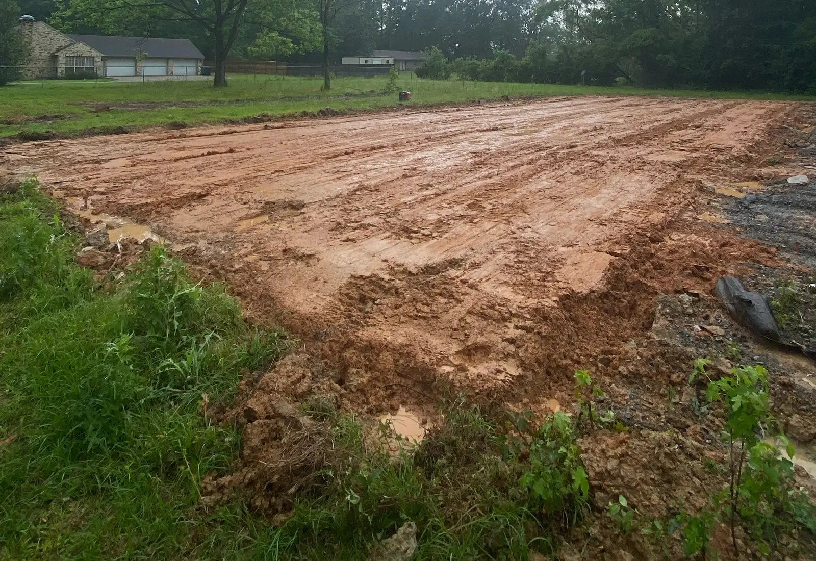 Freshly graded red dirt house pad on a cleared north Louisiana lot
