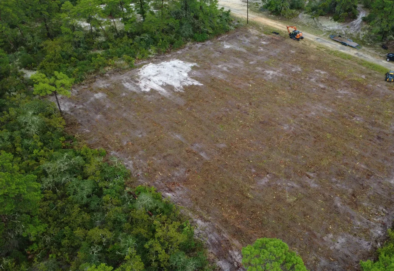 Overhead view of a cleared, smoothed building lot cut out of sandy pine woods